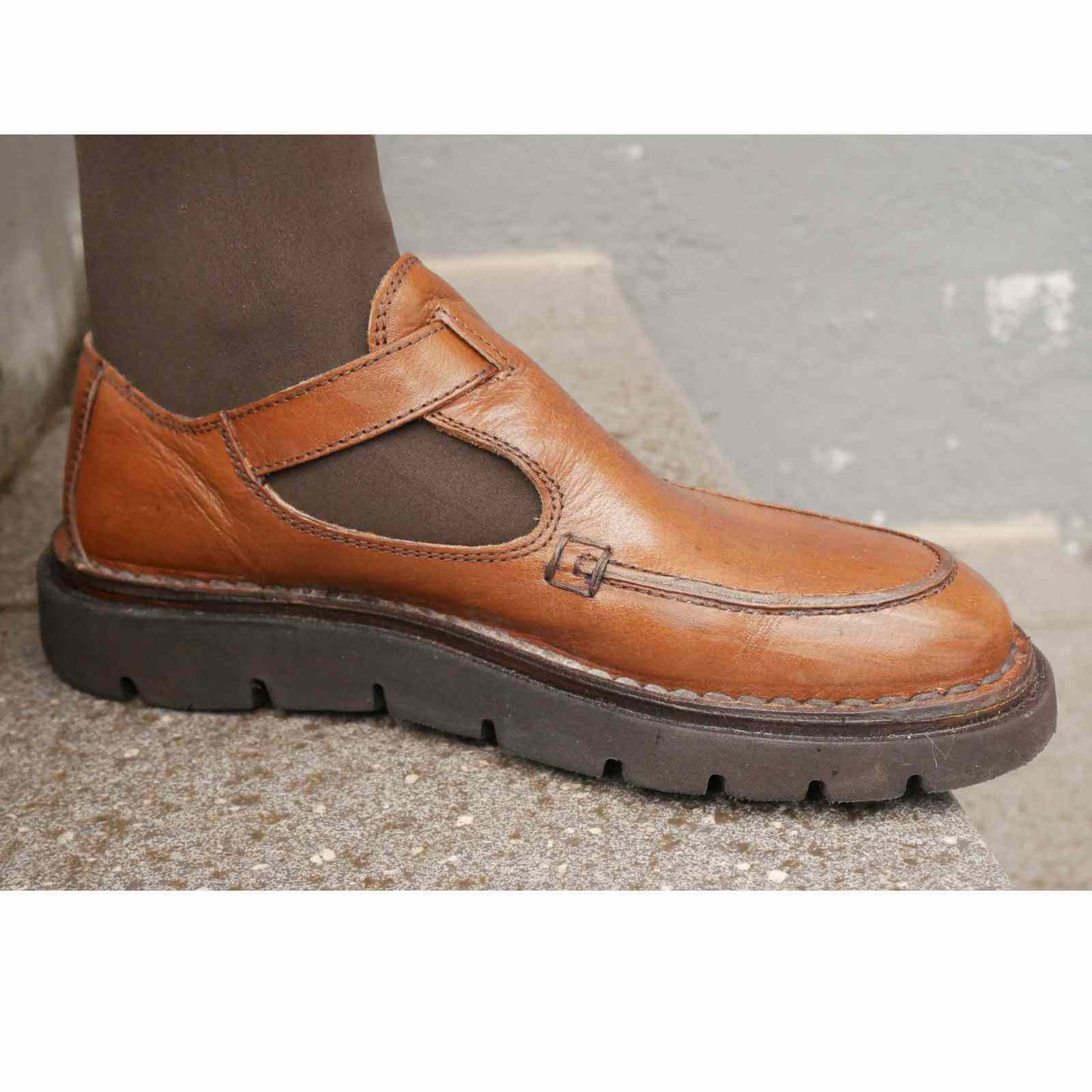 Inderside på lukket t-rem sko i cognac med brun strømpe
