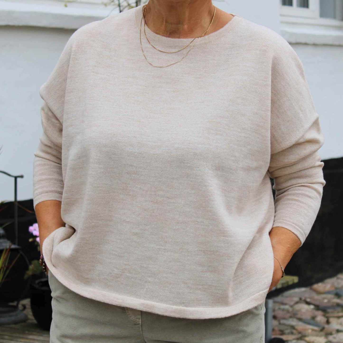 Cremefravet fin merinould bluse på kvinde
