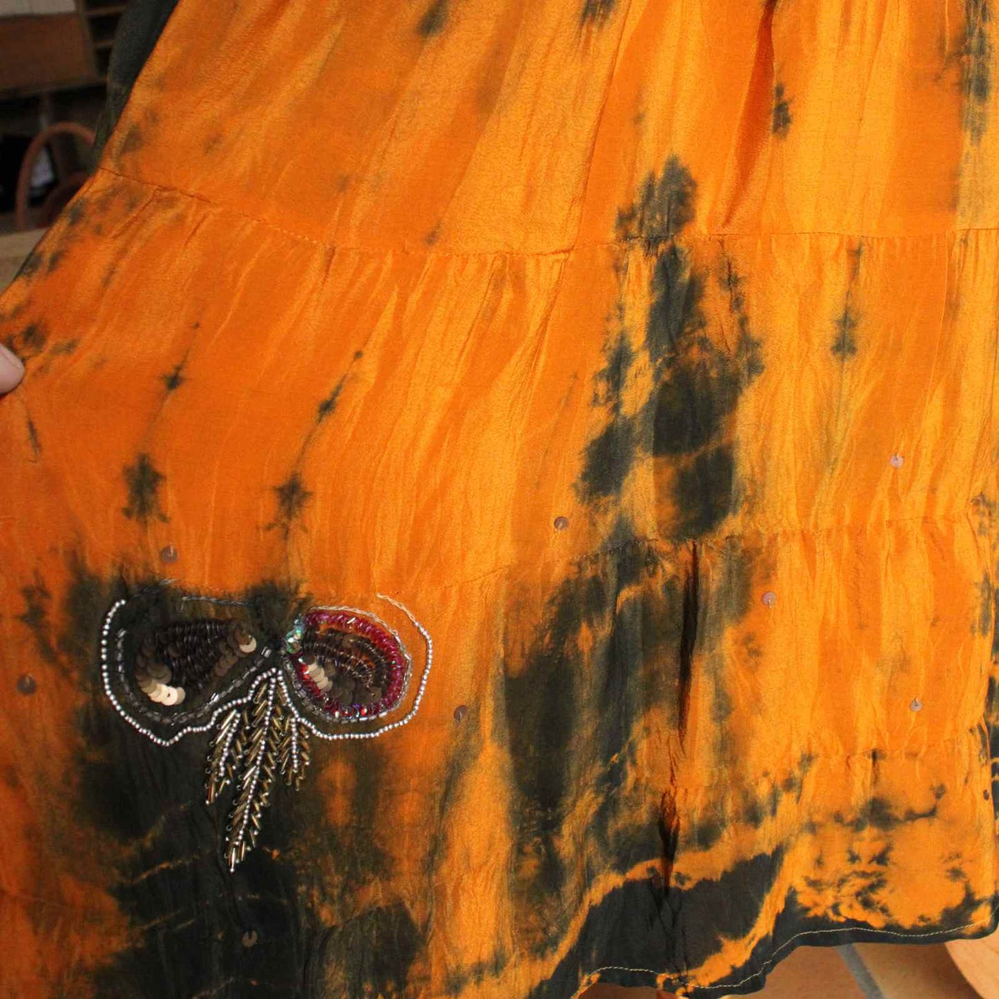 broderi på orange og sort silkekjole