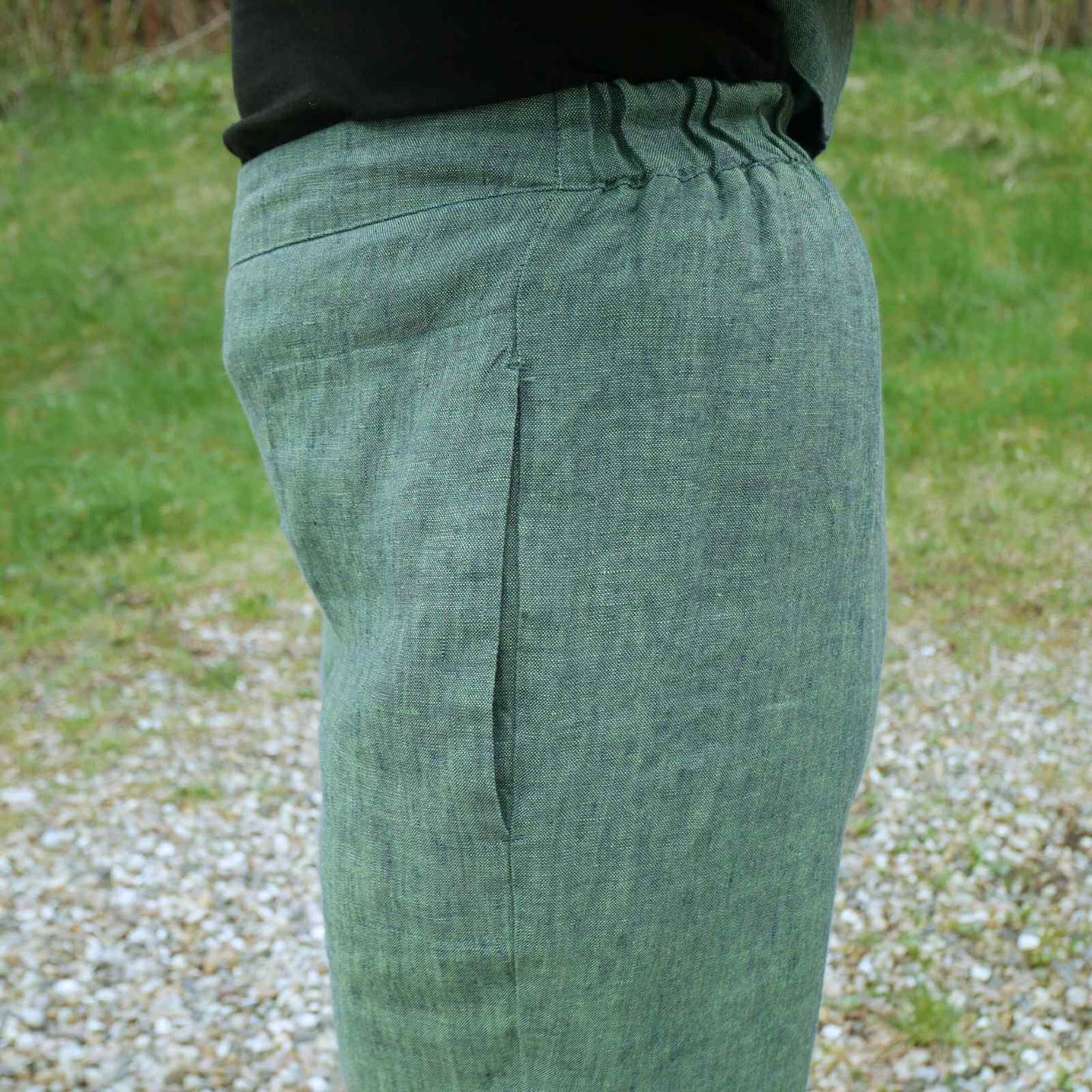 grønne hørbukser med elastik i lænden fra siden.