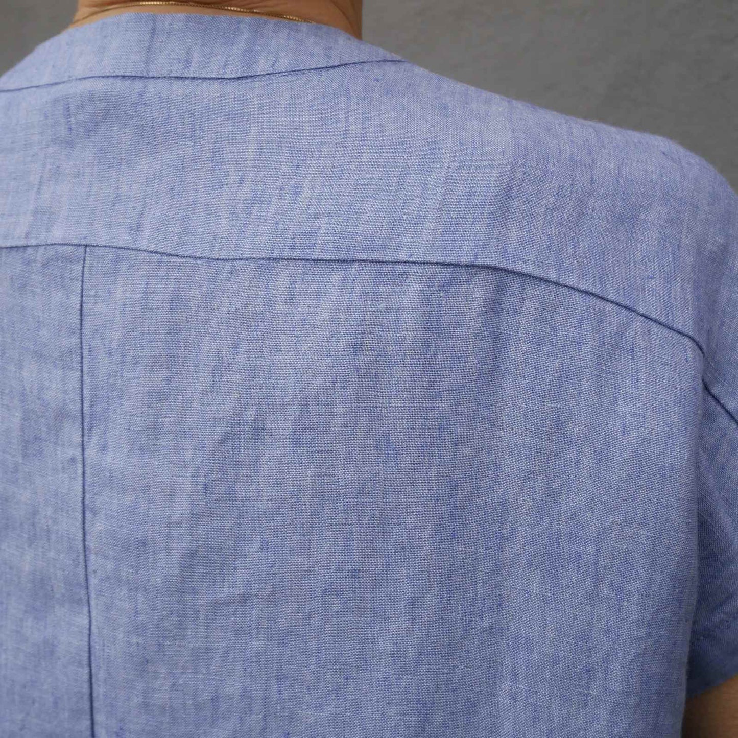 Nærbillede af meleret hør stof på lyseblå bluse