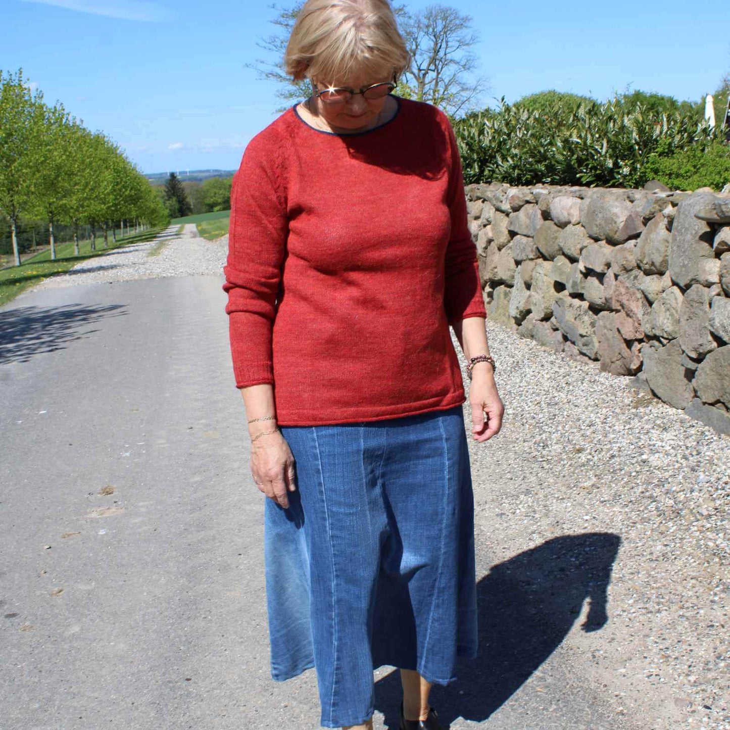 Anbi Jette i rød striktrøje og blå jeans nederdel