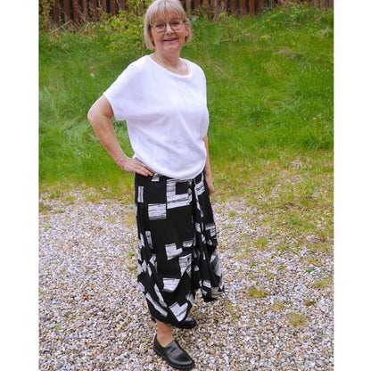 Anbi Jette i hvid bluse og sort hvid nederdel på græs baggrund