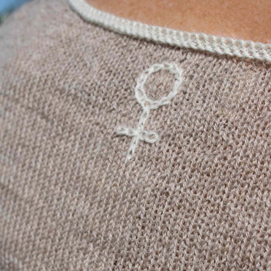 kvindetegn i nakken på beige stritrøje