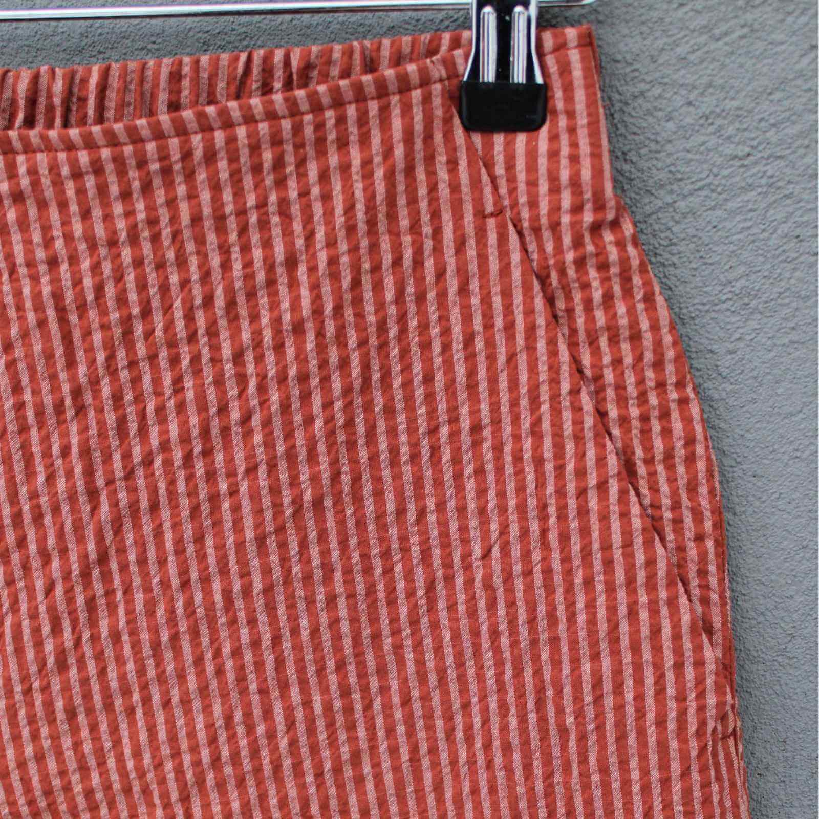 Skrå sidelomme detalje på kopperfarvet bukser fra Oska