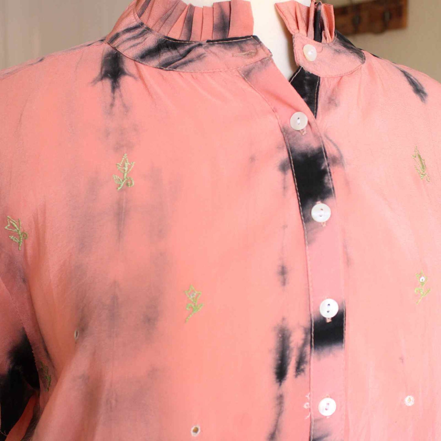 knapper og broderi detaljer på ferskefarvet silketop fra Cofur