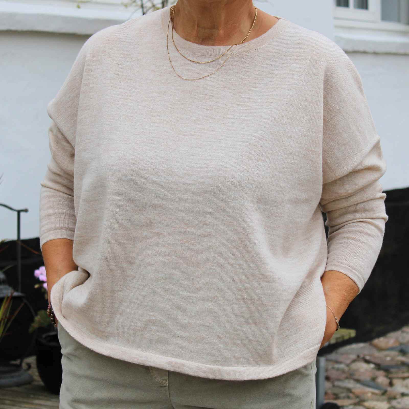 Cremefravet fin merinould bluse på kvinde