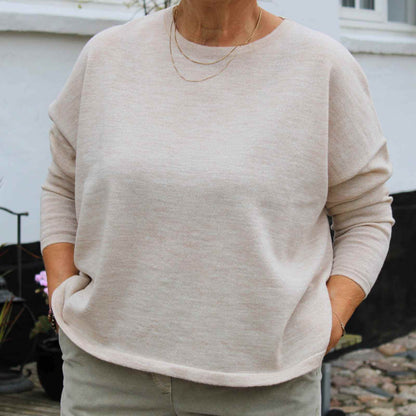 Cremefravet fin merinould bluse på kvinde
