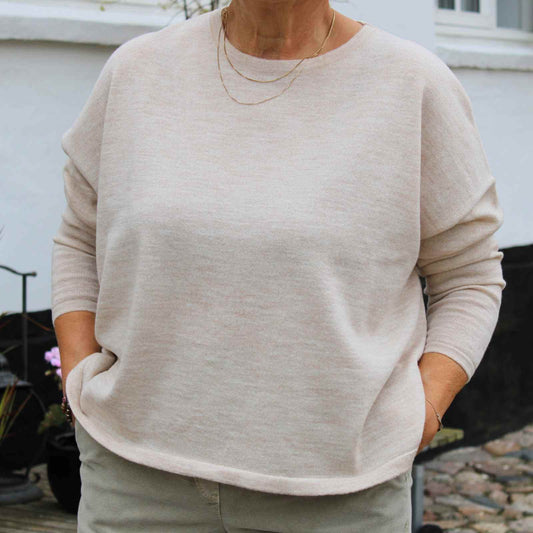 Cremefravet fin merinould bluse på kvinde