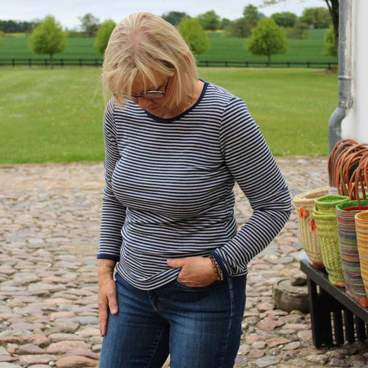 Anbi jette i blåstribet langærmet bluse og jeans foran kurve