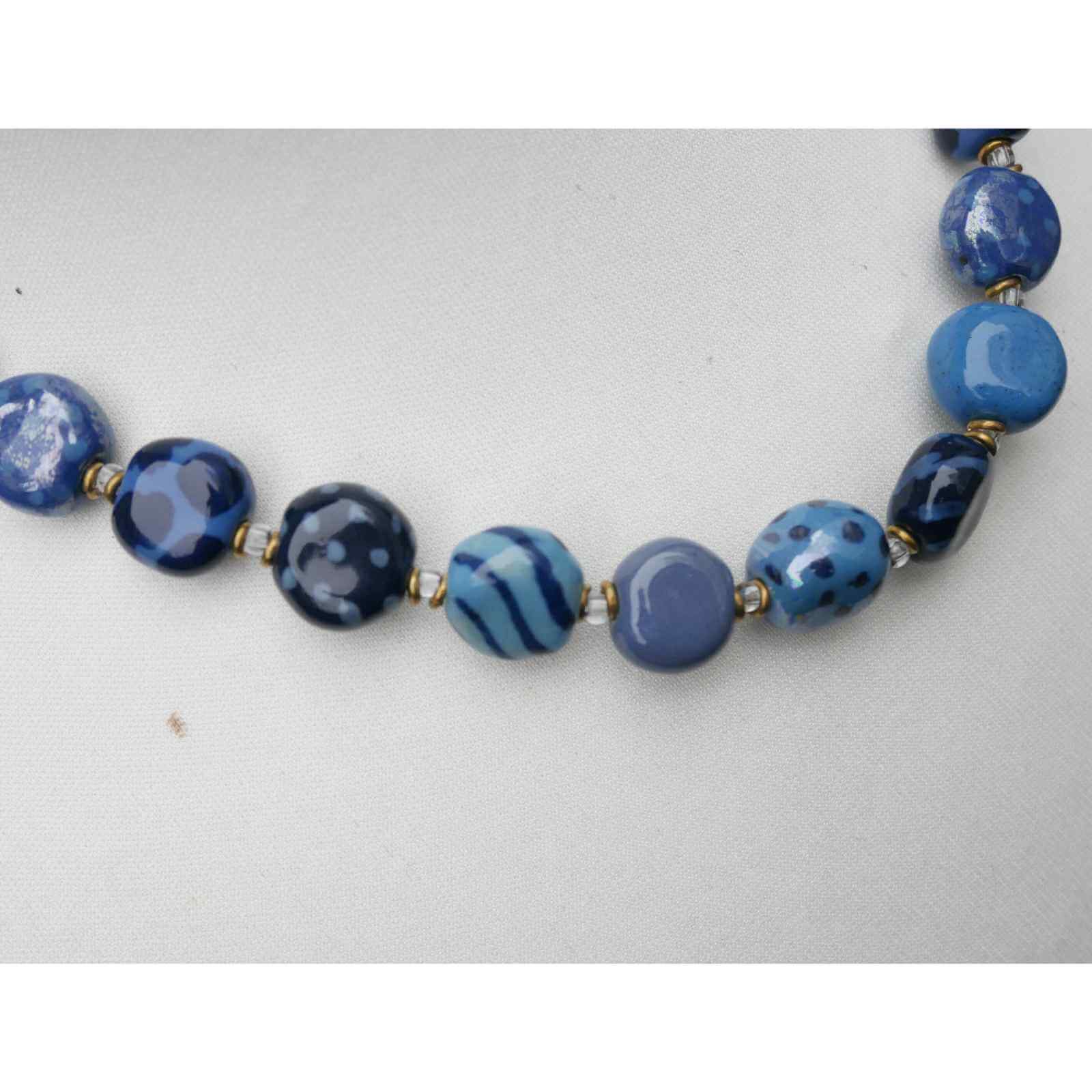Nærbillede af blå håndmalet perler på halskæde