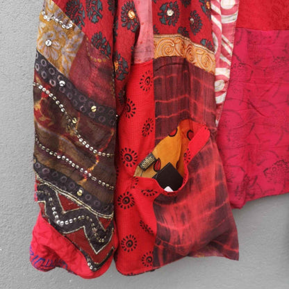 Lomme og ærme detalje på rød vendbar silkejakke fra Cofur