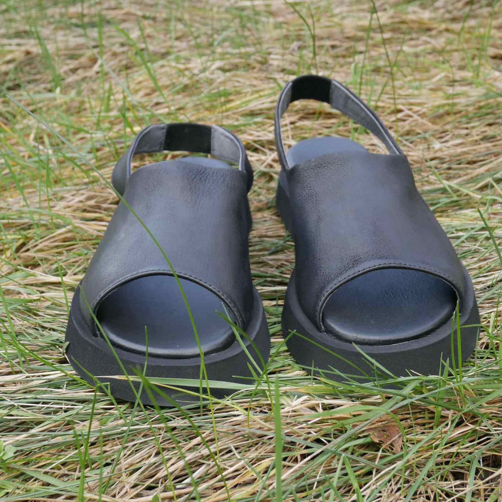 sorte skind sandaler med åben tå i græs