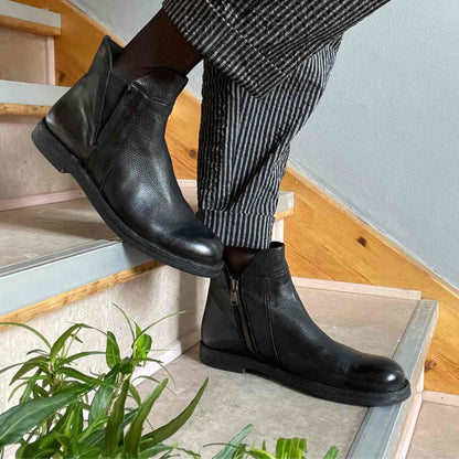 sorte støvler på Anbi trappe til stribet bukser