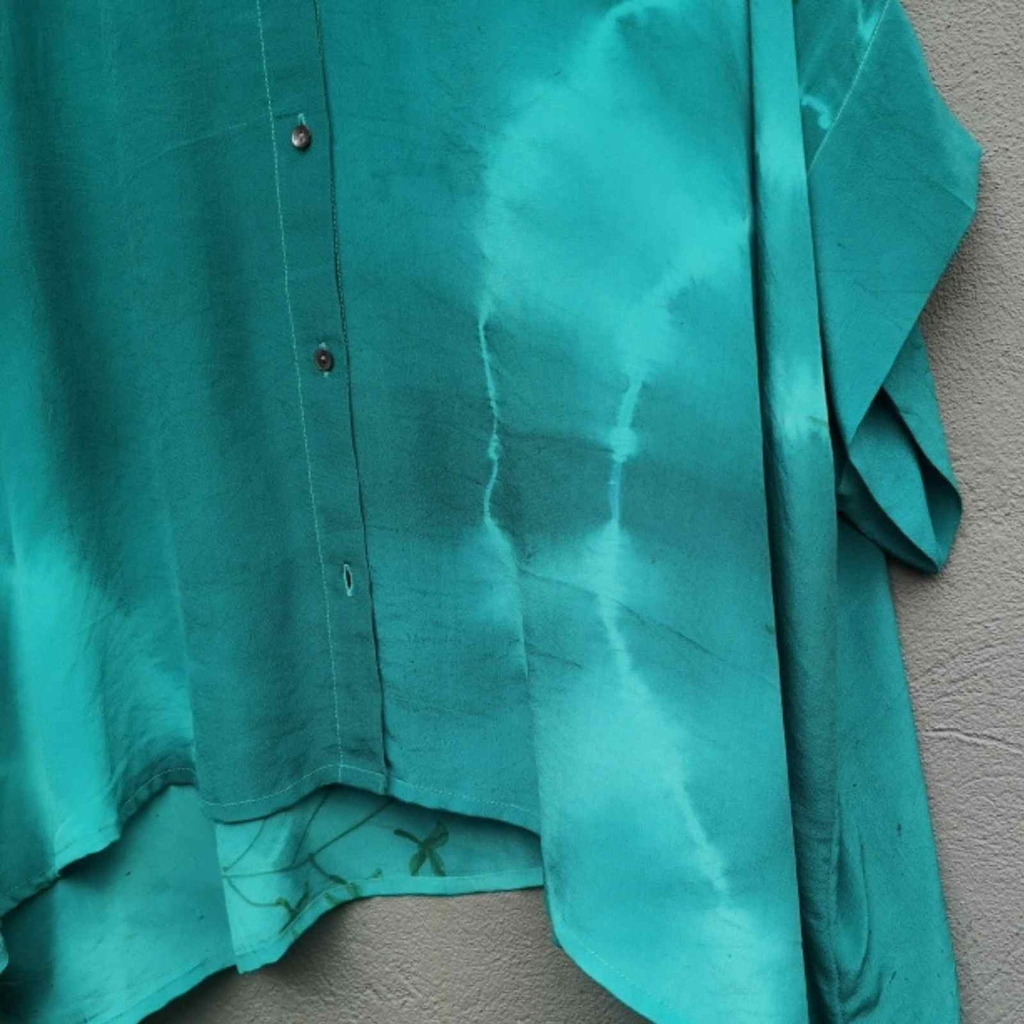 Knapper og ærme på turkis silkeskjorte