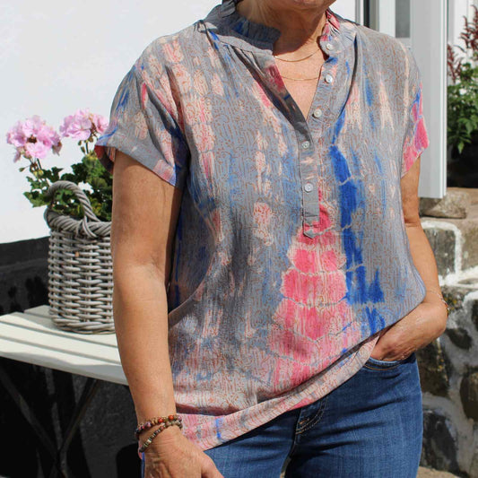 grå, pink og blå silketop på kvinde med blå jeans